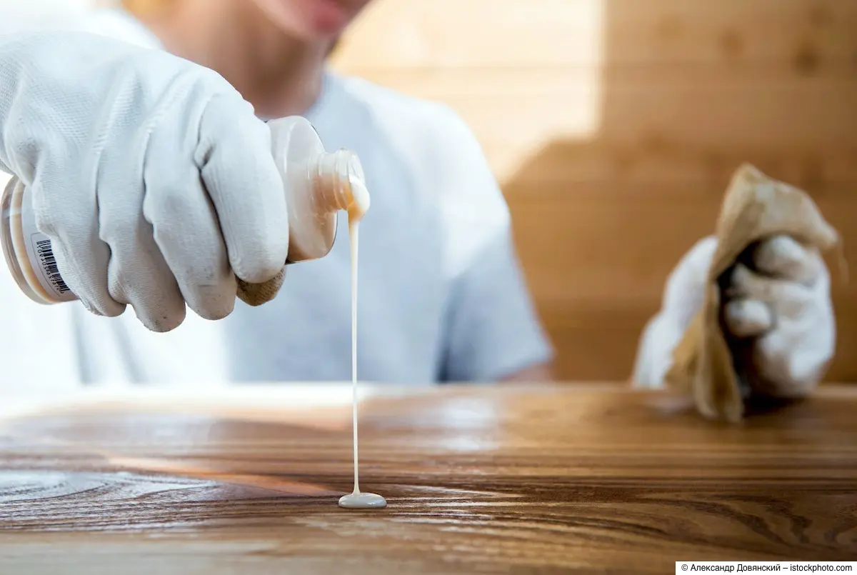 Junge Frau bereitet das Einölen einer Holztischplatte vor