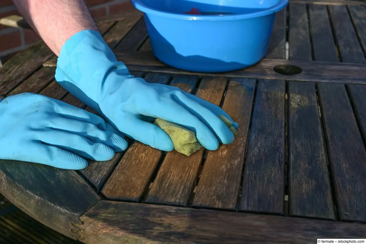 Reinigung eines verwitterten hölzernen Gartentischs