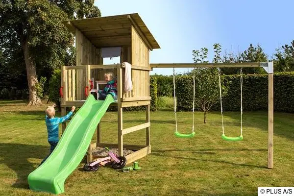 Mit einem Spielturm wird der Garten zum Paradies für Holzspielturm mit Rutsche und Schaukeln in einem grünen Garten, auf dem zwei Kinder spielen.