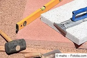Steinplatten werden auf Kiesschicht verlegt