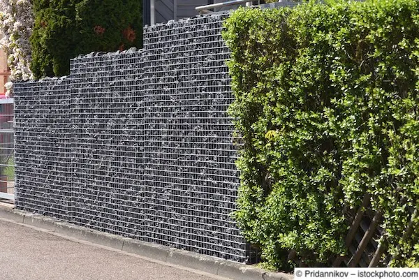 Gabionenwand, kombiniert mit anschließender Hecke und Jägerzaun