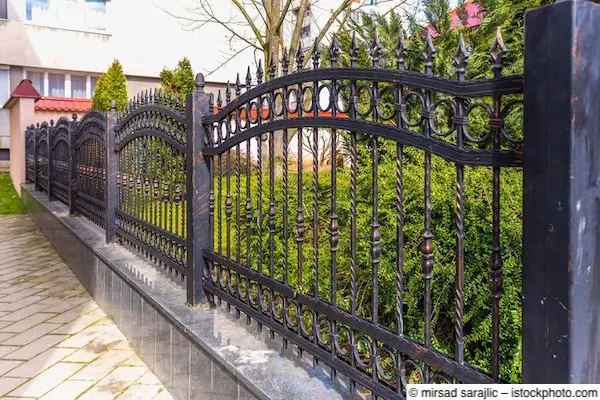 Schwarzer schmiedeeiserner Zaun vor Stadtvilla